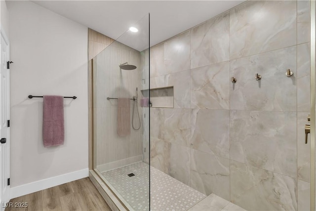 bathroom featuring baseboards, recessed lighting, a walk in shower, and wood finished floors