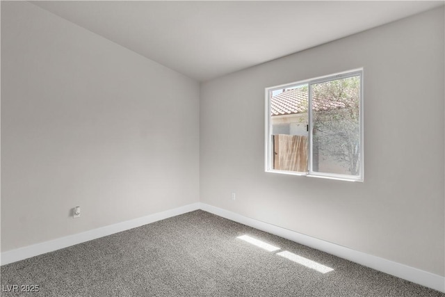 carpeted spare room featuring baseboards