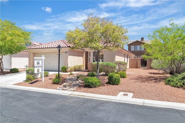 view of front facade with concrete driveway, a tiled roof, an attached garage, and stucco siding