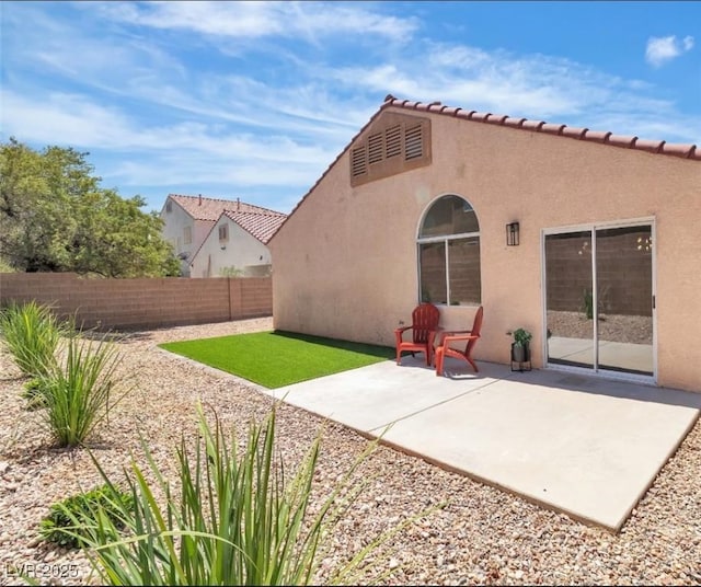 back of property featuring a fenced backyard, stucco siding, and a patio area