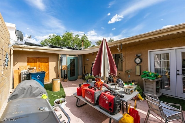 rear view of house featuring a patio, stucco siding, and french doors