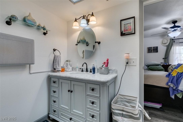 ensuite bathroom featuring vanity, ceiling fan, wood finished floors, and connected bathroom