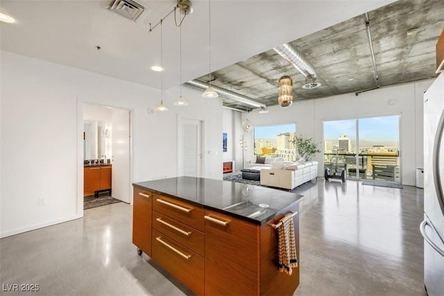 kitchen featuring dark countertops, modern cabinets, finished concrete floors, and visible vents