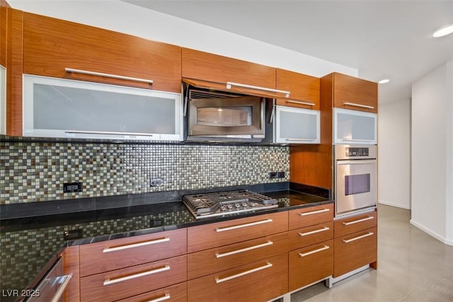 kitchen featuring modern cabinets, backsplash, dark countertops, and stainless steel appliances