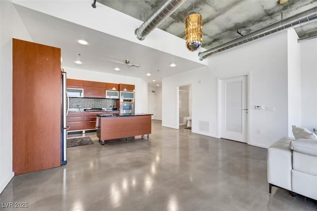 living area with recessed lighting, finished concrete flooring, and baseboards