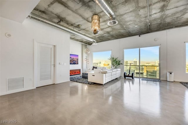 living room with visible vents, baseboards, and concrete flooring