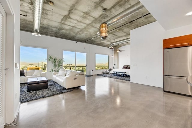 living area featuring concrete flooring and ceiling fan