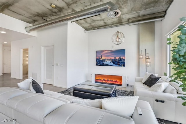 living area with a warm lit fireplace and baseboards