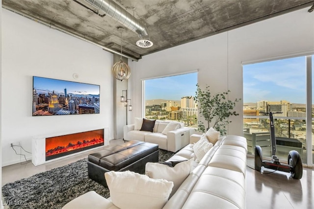 living room with a city view and a warm lit fireplace