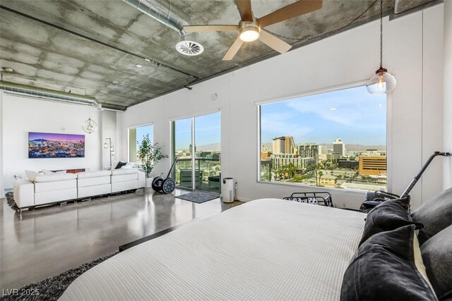 bedroom with a view of city, ceiling fan, finished concrete floors, and access to exterior