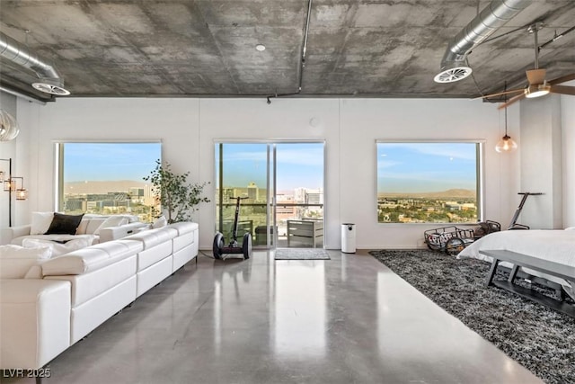 bedroom with multiple windows, access to outside, and finished concrete floors