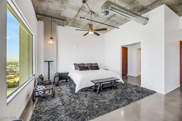 bedroom with baseboards, a towering ceiling, concrete flooring, and ceiling fan