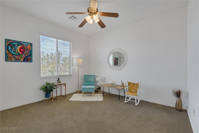 sitting room with visible vents, carpet flooring, baseboards, and ceiling fan