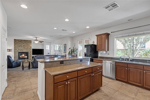kitchen featuring ceiling fan, a sink, dishwasher, a kitchen island, and visible vents