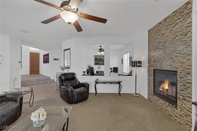 living room featuring carpet floors, a fireplace, and a ceiling fan