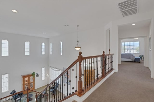 hallway with carpet, an upstairs landing, recessed lighting, and visible vents