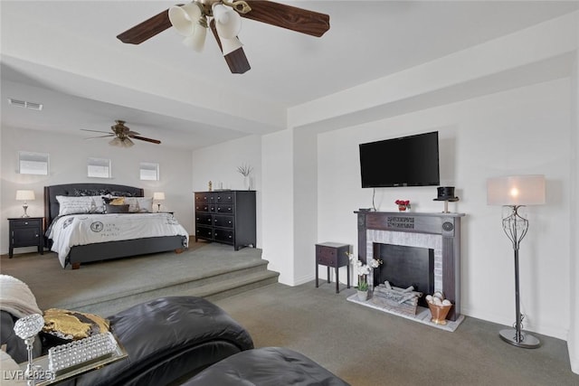 carpeted bedroom with baseboards, a fireplace, a ceiling fan, and visible vents