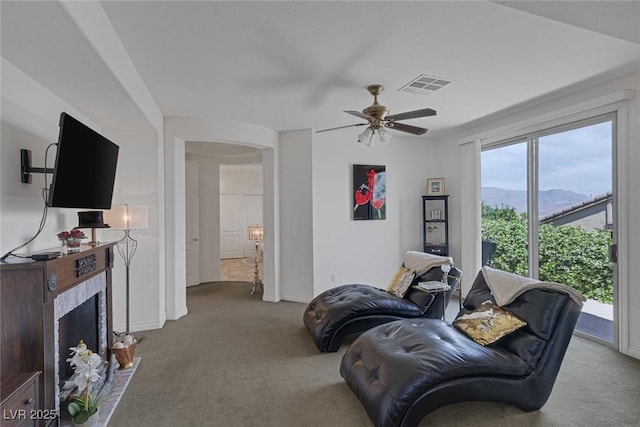 living room with carpet, a ceiling fan, baseboards, visible vents, and a mountain view