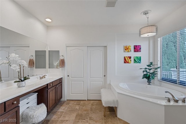 full bath with visible vents, a garden tub, and vanity
