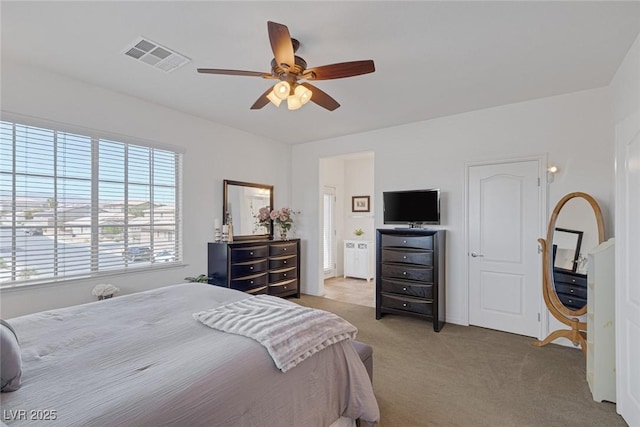 bedroom with ceiling fan, visible vents, and carpet