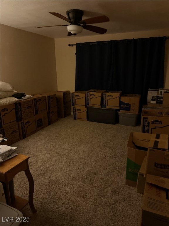 interior space featuring a ceiling fan and carpet