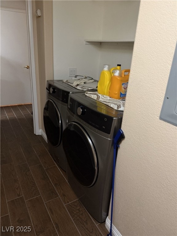clothes washing area featuring wood tiled floor, baseboards, laundry area, and washer and clothes dryer