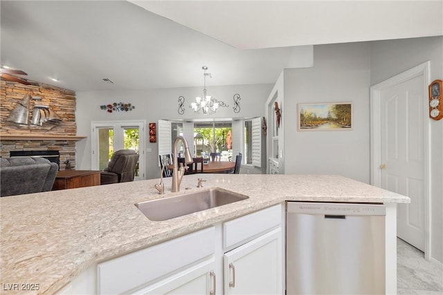 5200 Wheatland Dr, Pahrump, NV 89061 - kitchen featuring white cabinets, a notable chandelier, a sink, a fireplace, and dishwasher