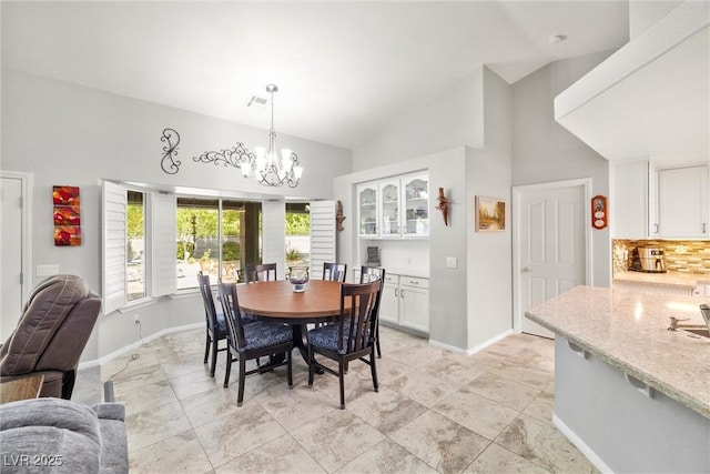 5200 Wheatland Dr, Pahrump, NV 89061 - dining room featuring baseboards, a chandelier, high vaulted ceiling, and visible vents