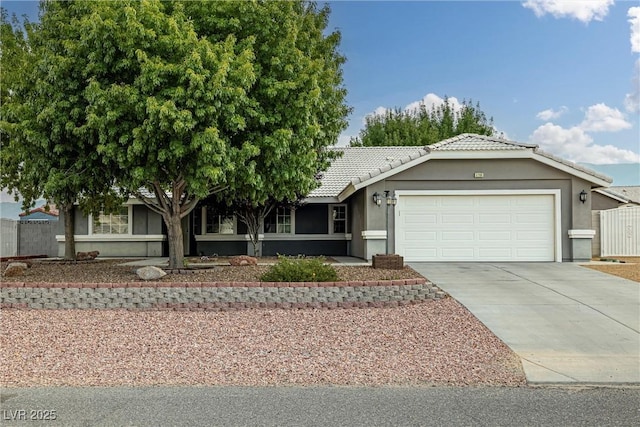 5200 Wheatland Dr, Pahrump, NV 89061 - ranch-style home featuring fence, an attached garage, stucco siding, a tiled roof, and driveway