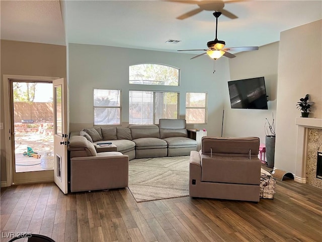 living room featuring a ceiling fan, visible vents, and hardwood / wood-style floors
