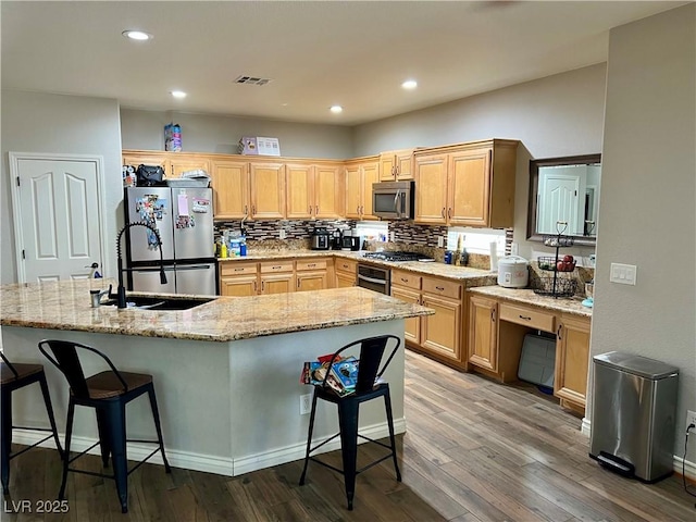 kitchen featuring a sink, stainless steel appliances, hardwood / wood-style floors, and visible vents
