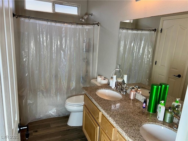 full bath with a sink, double vanity, toilet, curtained shower, and wood finished floors