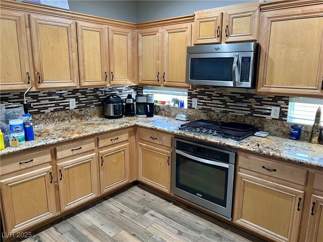 8928 Reining Spur Ave, Las Vegas, NV 89143 - kitchen with appliances with stainless steel finishes, backsplash, light wood-type flooring, and light stone counters