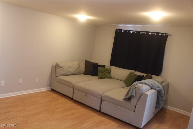 living area with baseboards and light wood finished floors