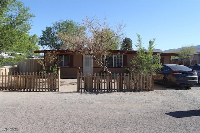 view of front of house with a fenced front yard and stucco siding
