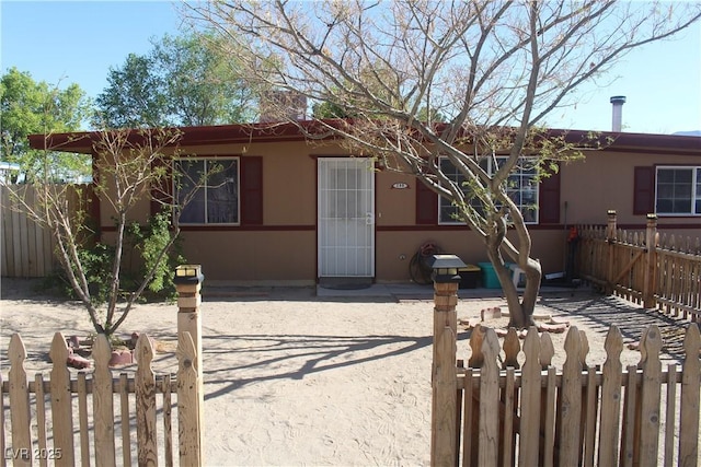 view of front of property with stucco siding and fence private yard