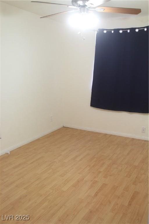 unfurnished room featuring a ceiling fan, baseboards, and light wood-style floors