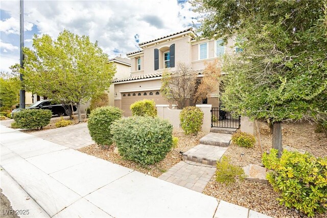 3163 Biccari Ave, Henderson, NV 89044 - mediterranean / spanish-style house featuring stucco siding, a tiled roof, an attached garage, a fenced front yard, and a gate
