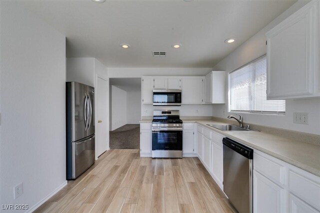 8877 Perfect Diamond Ct, Las Vegas, NV 89129 - kitchen featuring visible vents, appliances with stainless steel finishes, a sink, white cabinets, and light wood finished floors