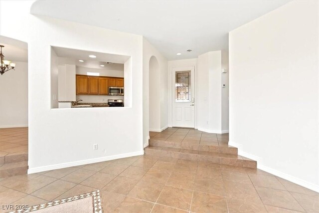 interior space with light tile patterned flooring, baseboards, an inviting chandelier, and recessed lighting