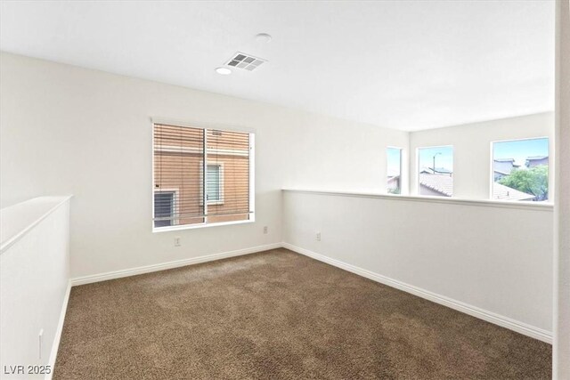 carpeted empty room with baseboards and visible vents