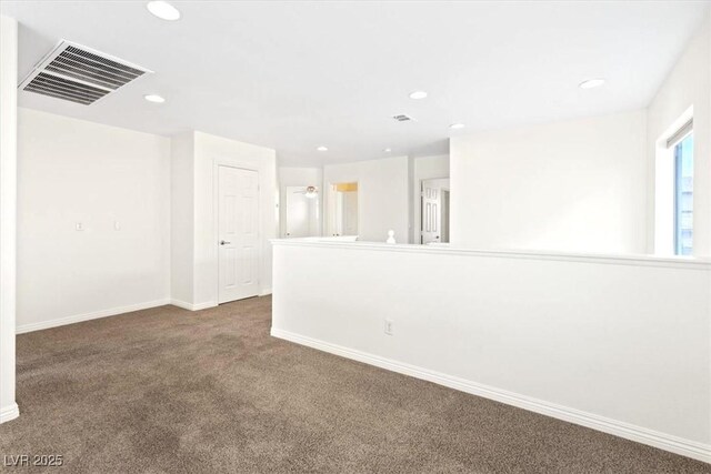 carpeted spare room featuring recessed lighting, baseboards, and visible vents