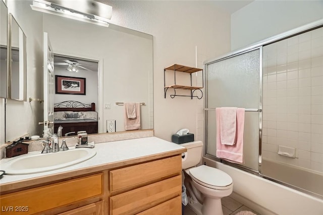 ensuite bathroom with vanity, toilet, a ceiling fan, combined bath / shower with glass door, and ensuite bath