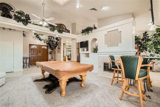 game room with a tile fireplace, a ceiling fan, billiards, a towering ceiling, and visible vents