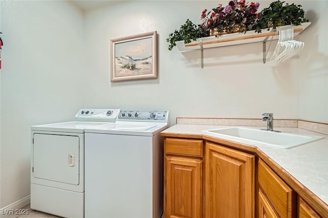 clothes washing area featuring cabinet space, separate washer and dryer, and a sink