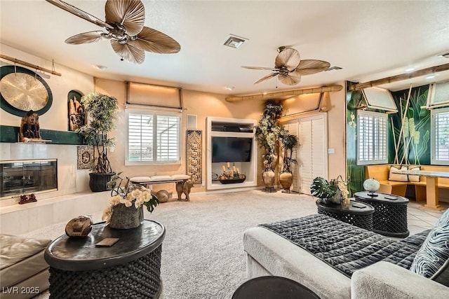 living room with ceiling fan, a fireplace, carpet flooring, and visible vents
