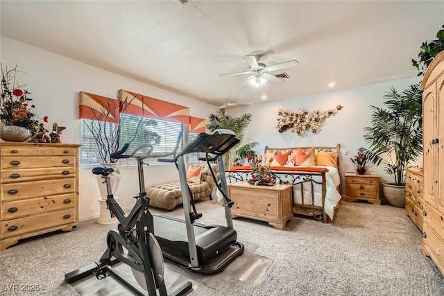 exercise room with a ceiling fan and light carpet