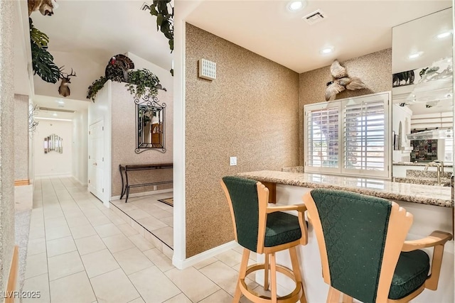 kitchen featuring visible vents, tile patterned flooring, light stone countertops, baseboards, and recessed lighting