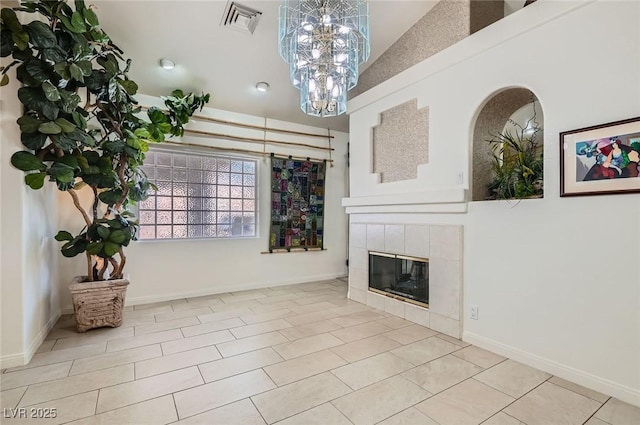 living room featuring baseboards, visible vents, an inviting chandelier, and a tile fireplace