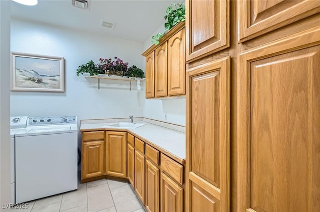 laundry room featuring visible vents, a sink, cabinet space, and washing machine and dryer